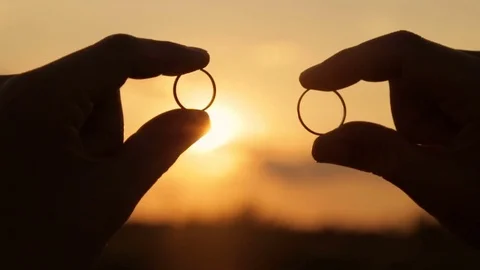 Rays of evening sun through wedding rings Stock Footage