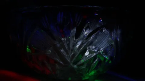 Rays of light of different colors sparkle on the edges of a crystal vase Stock Footage 107469579