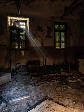 Rays of light filter through the window of a room of an abandoned madhouse Stock Photos