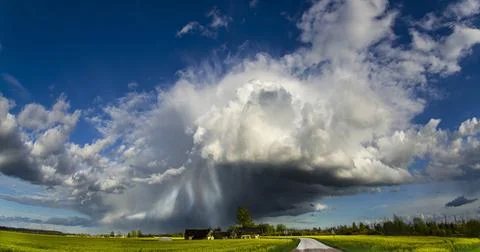 Rays of light shine down from a cloudy sky into a fields. Lithuania Stock Photos