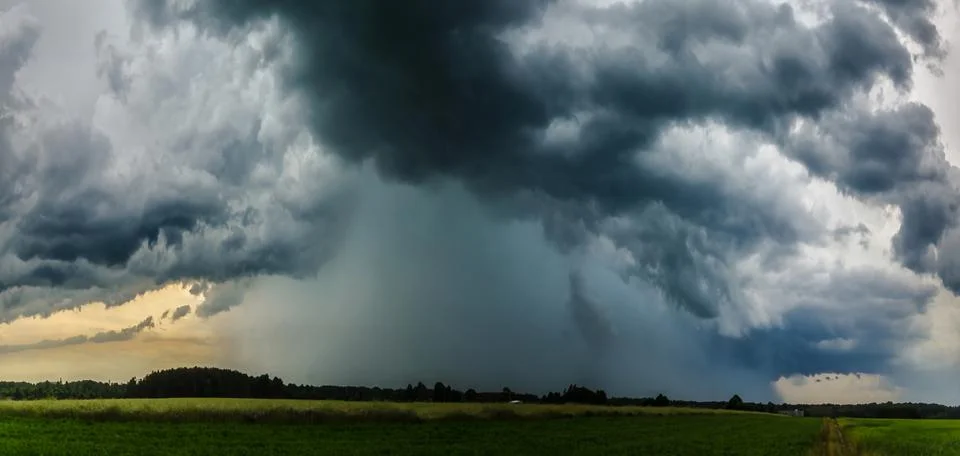 Rays of light shine down from a cloudy sky into a fields. Sun beams burstin.. Stock Photos