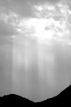 Rays of light shining through dark clouds Stock Photos