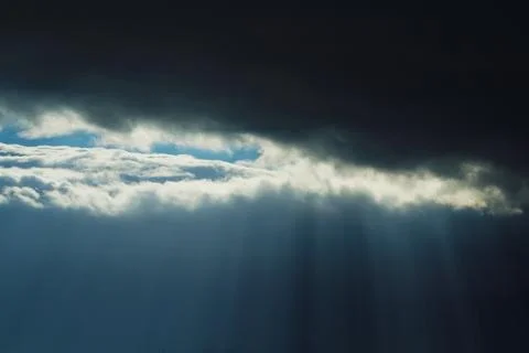 Rays of light through dark clouds Stock Photos