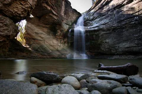 Rays of light through a rock and a waterfall Stock Photos