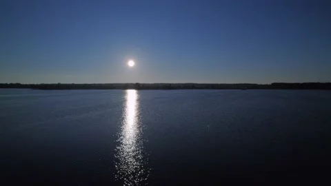 Rays of the rising sun reflect and shine on the surface of the lake Video stock 154556091
