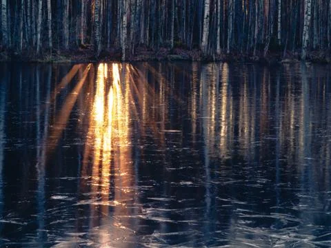 Rays of the setting sun are reflected in the river water which began to be co Stock Photos