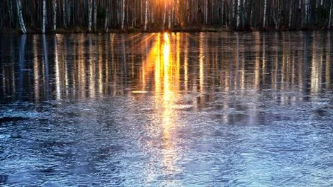 Rays of the setting sun are reflected in the river water which began to be co Stock Photos