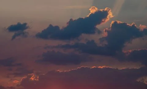 The rays of the setting sun break through the clouds. Sunset Stock Photos