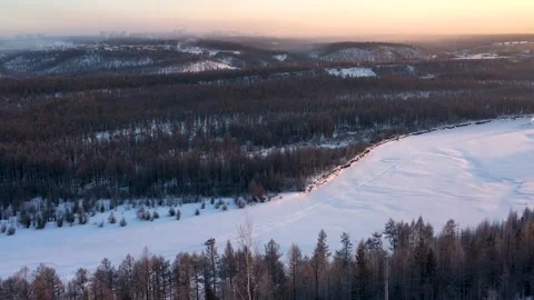 The rays of the setting sun illuminate the frozen river 스톡 동영상 222721857