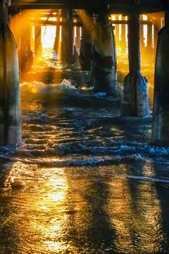 The rays of the setting sun illuminate the pier. Stock-Fotos
