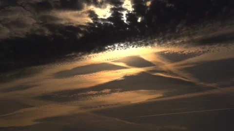 The rays of the setting sun make their way through the glowing clouds. Video stock 105292961