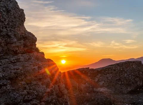 The rays of the setting sun make their way through a piece of rock Stock Photos