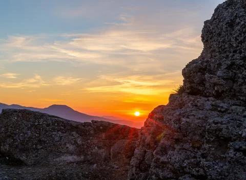 The rays of the setting sun make their way through a piece of rock Stock Photos