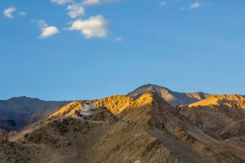 Rays of the setting sun over the Tibetan temple in the mountains Stock Photos