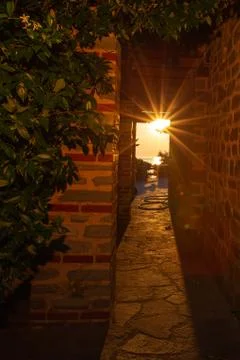 The rays of the setting sun shine through the narrow long arch of the building Stock Photos