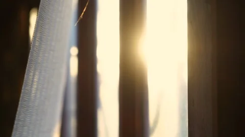 Rays of setting sun through the roller blinds on window. Video stock 118387211