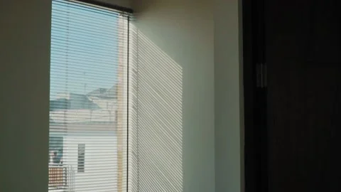 Rays of setting sun through the roller blinds on window, Sunshine over the Video stock 148453256