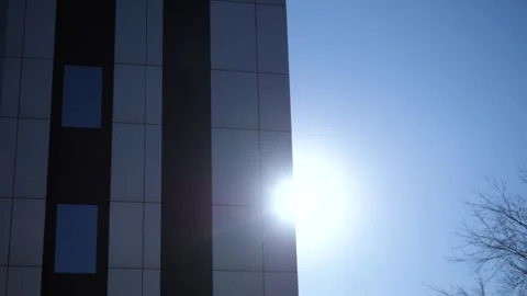 Rays of sun appearing from behind a modern office or other building. Stock Footage 302828269