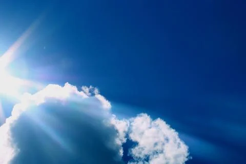 The rays of the sun break through the clouds. Beautiful blue sky after the rain. Stock Photos