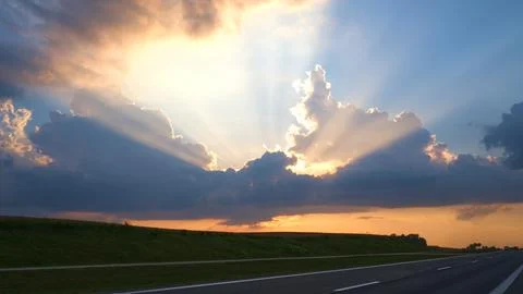 The rays of the sun breaking through the clouds view near the highway Stock Photos