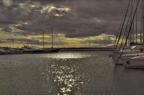 Rays of the sun breaking through thunderclouds over the harbor Stock Photos
