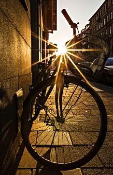 Rays of sun coming through the bicycle silhouette, bike at sunset. Stock Photos