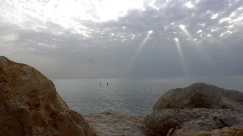 Rays of the sun illuminate surfers on the boards Stockbeeldmateriaal 88904013