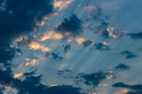 The rays of the sun make their way through the dark clouds Stock Photos