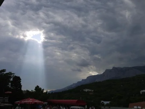 The rays of the sun, making their way through gray rain clouds Stock Photos