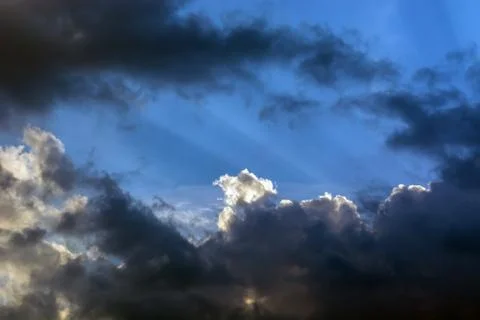 Rays of the sun making their way through the clouds against the backdrop of t Stock Photos