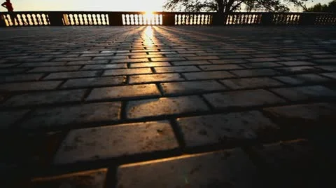 Rays of sun over parapet on tile sidewalk Stock Footage 11365409