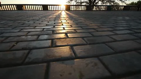 Rays of sun over parapet on tile sidewalk Vidéo 11365422
