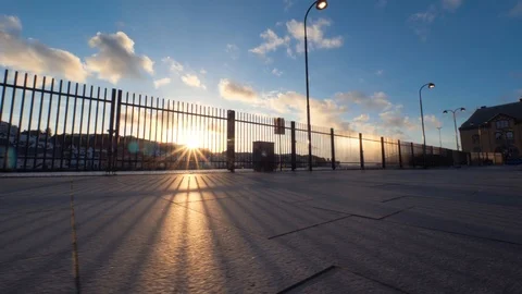 Rays of the sun shine through the fence. Walking on the city embankment in good Stock Footage 87846829