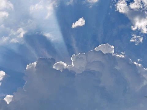 The rays of the sun in the sky make their way through dense white clouds. Lig Stock Photos