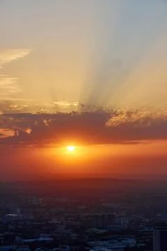 Rays of the sun at sunset over the Almaty city, Kazakhstan Stock Photos