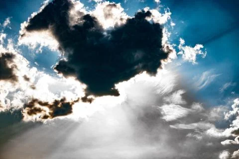 Rays of sunlight behind the clouds. High contrast. Stock Photos