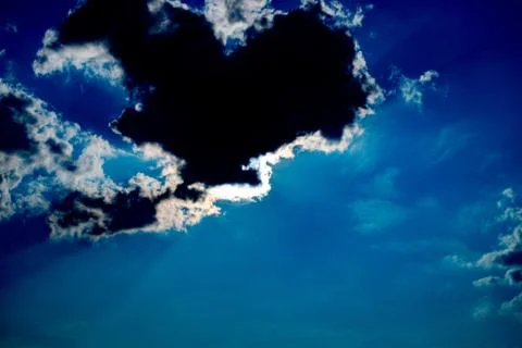 Rays of sunlight behind the clouds. High contrast. Stock Photos