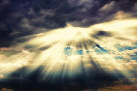Rays of sunlight coming through dramatic clouds Stock Photos