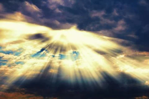 Rays of sunlight coming through dramatic clouds Stock Photos