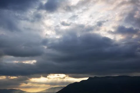 Rays of sunlight coming through dramatic clouds Stock Photos