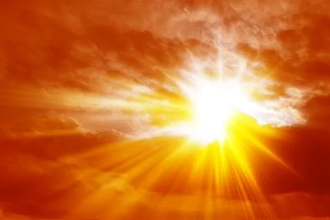 Rays of sunlight crossing the clouds in a fiery red sky Foto stock