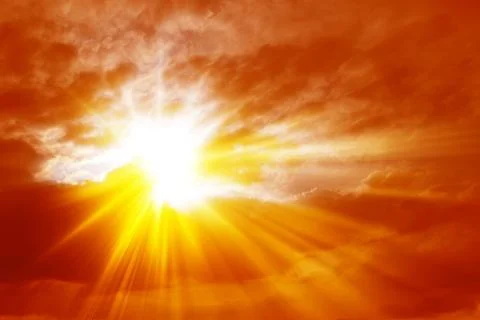Rays of sunlight crossing the clouds in a fiery red sky Stock Photos