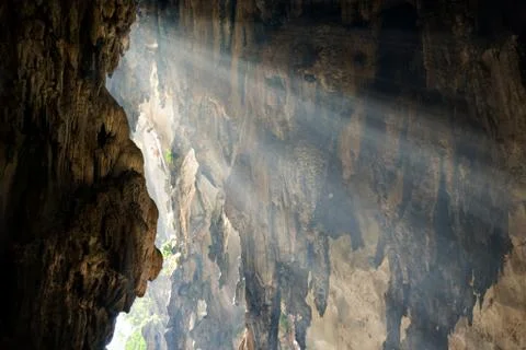 Rays of sunlight fall on the wall of cave. Concept of hope, discovery. Stock Photos