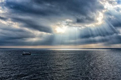 Rays through thick clouds over sea Stock Photos