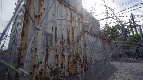 Razor barbed wire barricade in front of shipping containers. Vídeos de archivo 158135413