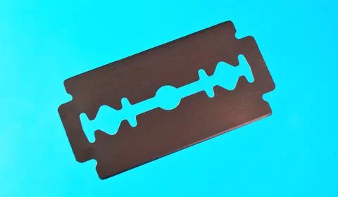 Razor blade on a blue background. Stock Photos