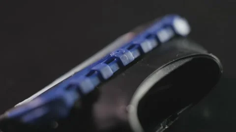 The razor blade rotates on a dark background in close-up Vídeo Stock 165991355