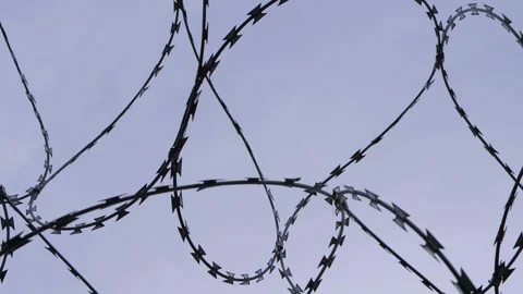 Razor wire against dark sky rotating Stock Footage 146857926