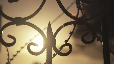 Razor wire on steel gate of old masion sunset back light Stock Footage 48721859