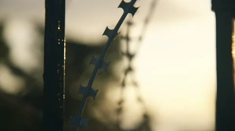 Razor wire on steel gate of old masion with no tresspassing sign pan rack focus Stock Footage 48725535